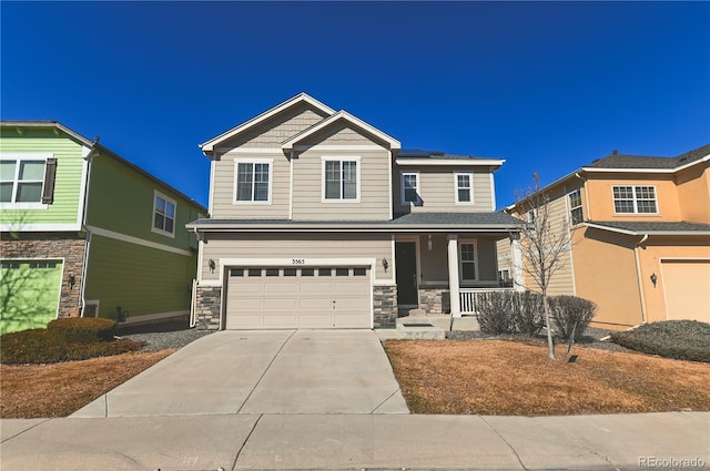 craftsman-style home featuring a garage, solar panels, concrete driveway, stone siding, and a porch