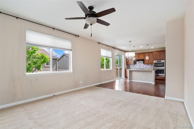 3565 E 141st Dr, Thornton, CO 80602 - unfurnished living room featuring dark colored carpet, recessed lighting, baseboards, a ceiling fan, and a chandelier