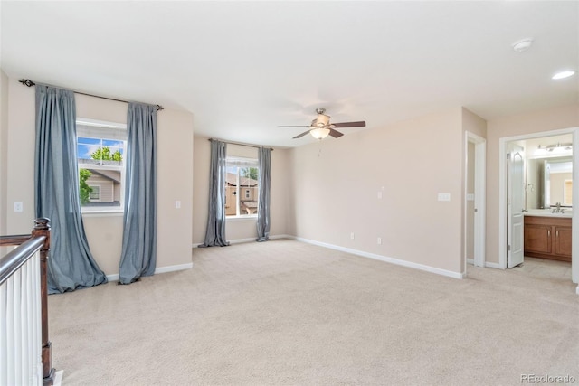 3565 E 141st Dr, Thornton, CO 80602 - unfurnished living room featuring light colored carpet, ceiling fan, a sink, and healthy amount of natural light