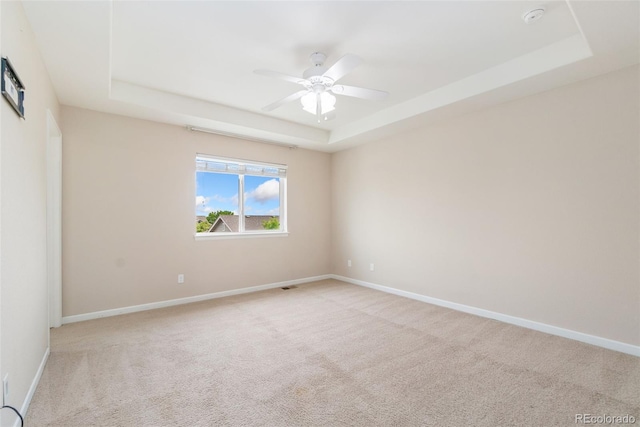 3565 E 141st Dr, Thornton, CO 80602 - spare room featuring a raised ceiling, light carpet, a ceiling fan, and baseboards