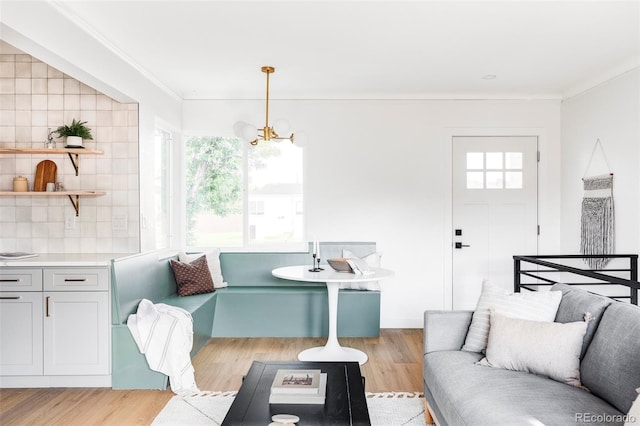 living area featuring ornamental molding, light wood-type flooring, and a wealth of natural light