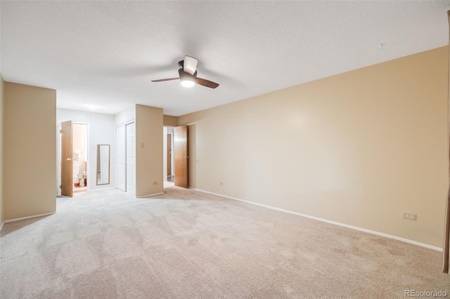 carpeted empty room with ceiling fan and a textured ceiling