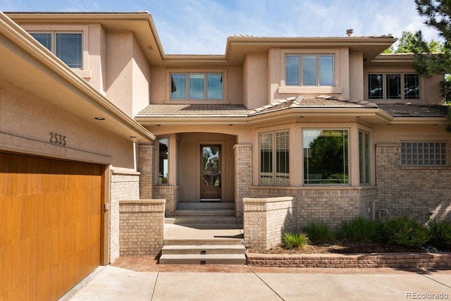 2535 W 115th Dr, Westminster, CO 80234 - doorway to property with stucco siding, brick siding, and a garage