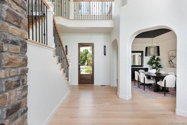 2535 W 115th Dr, Westminster, CO 80234 - foyer with light wood finished floors, arched walkways, stairs, baseboards, and a towering ceiling