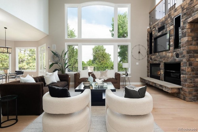 2535 W 115th Dr, Westminster, CO 80234 - living area featuring a towering ceiling, light wood-type flooring, and a stone fireplace