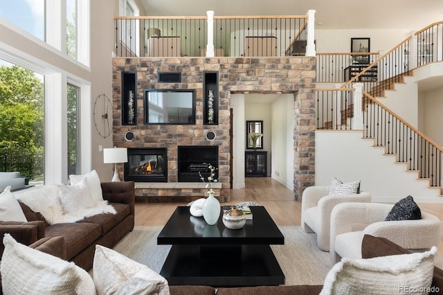 2535 W 115th Dr, Westminster, CO 80234 - living area with a towering ceiling, plenty of natural light, stairs, a stone fireplace, and wood finished floors