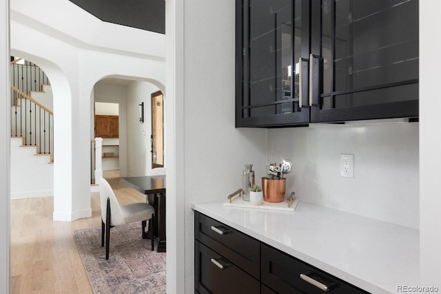 2535 W 115th Dr, Westminster, CO 80234 - bar featuring light wood-type flooring, stairway, and arched walkways