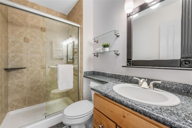 bathroom featuring toilet, a stall shower, and vanity