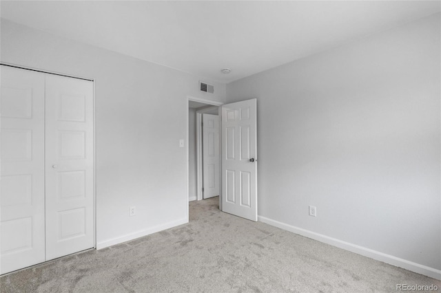 unfurnished bedroom featuring carpet floors, baseboards, and a closet