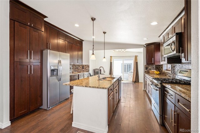 1522 Willow St, Denver, CO 80220 - kitchen featuring stainless steel appliances, a sink, tasteful backsplash, dark wood-style floors, and light stone countertops