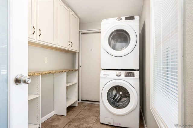 1522 Willow St, Denver, CO 80220 - laundry area with stacked washer / dryer, cabinet space, and light tile patterned floors
