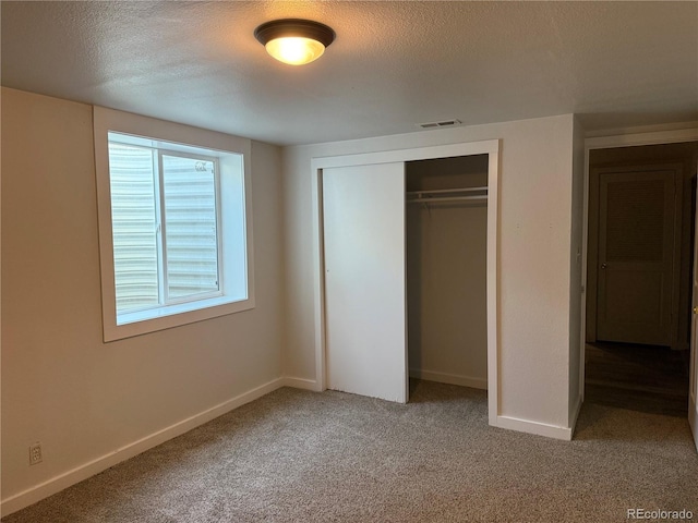 1906 Larkspur Dr, Fort Collins, CO 80521 - unfurnished bedroom with a closet, baseboards, light carpet, and a textured ceiling