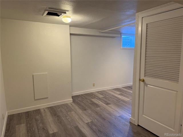 1906 Larkspur Dr, Fort Collins, CO 80521 - below grade area with dark wood-type flooring, visible vents, a textured ceiling, and baseboards
