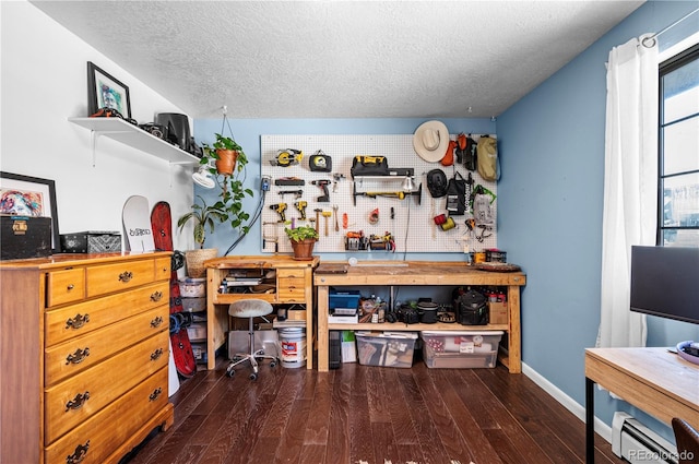 interior space featuring a textured ceiling, baseboards, dark wood-style flooring, and a workshop area