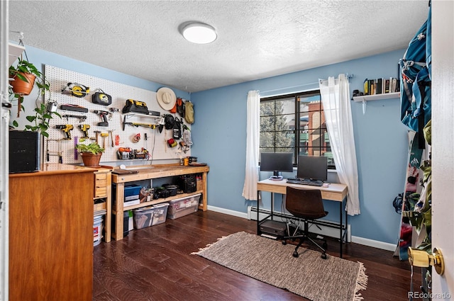 home office featuring dark wood-style floors, a baseboard heating unit, and baseboards