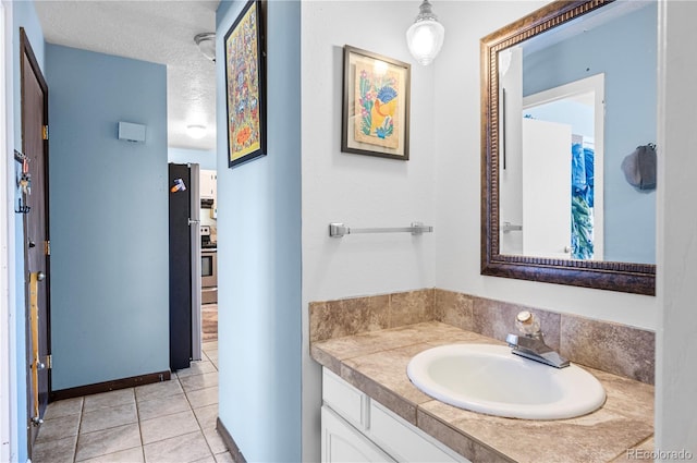 bathroom featuring a textured ceiling, vanity, and tile patterned floors