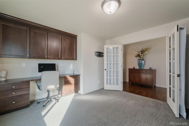 office featuring built in desk, french doors, and dark colored carpet