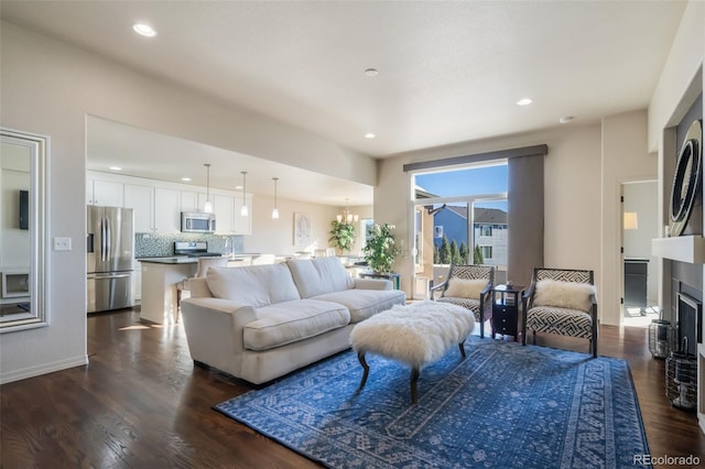 living room featuring dark wood-type flooring and a notable chandelier