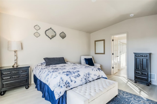 bedroom with lofted ceiling and light wood-type flooring