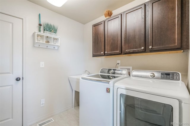 laundry room with cabinets and washing machine and clothes dryer