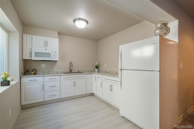 kitchen with light stone counters, sink, white appliances, and white cabinets