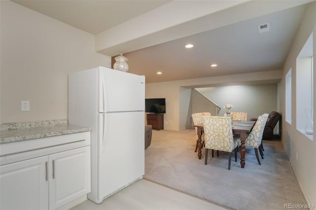 dining room featuring light carpet