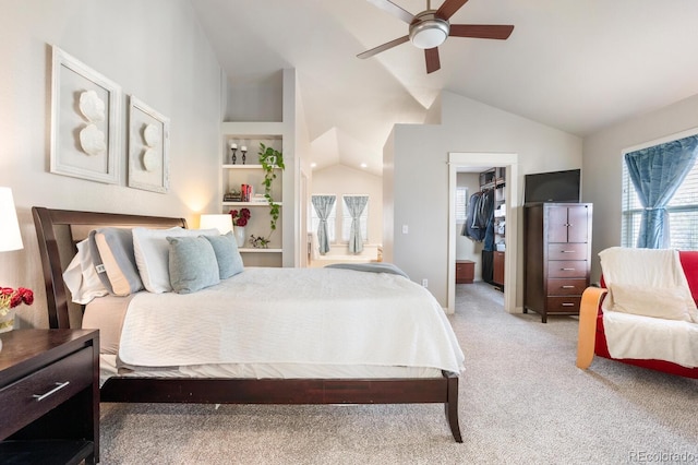 bedroom with a walk in closet, a closet, vaulted ceiling, ceiling fan, and light carpet