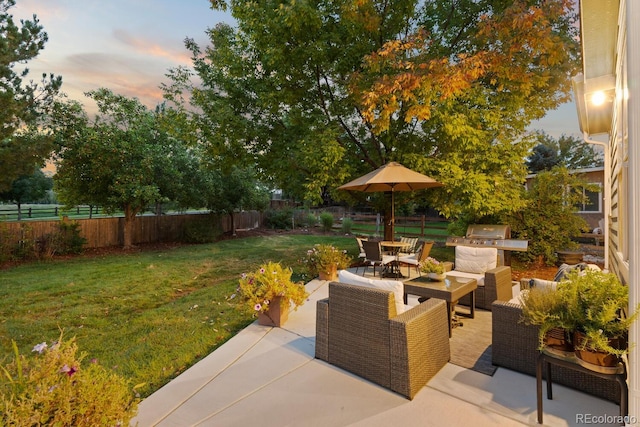 patio terrace at dusk with an outdoor hangout area and a lawn