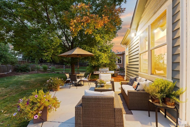 patio terrace at dusk featuring a yard and an outdoor hangout area