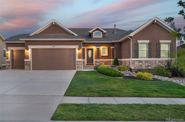 view of front of home featuring a garage and a yard