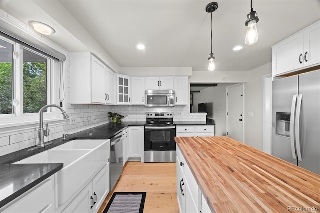 8035 S Garfield Way, Centennial, CO 80122 - kitchen featuring stainless steel appliances, butcher block counters, a sink, tasteful backsplash, and white cabinetry