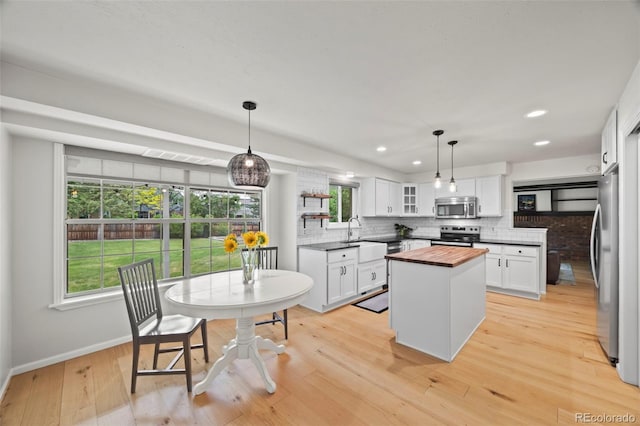 8035 S Garfield Way, Centennial, CO 80122 - kitchen with butcher block counters, stainless steel appliances, backsplash, a kitchen island, and baseboards