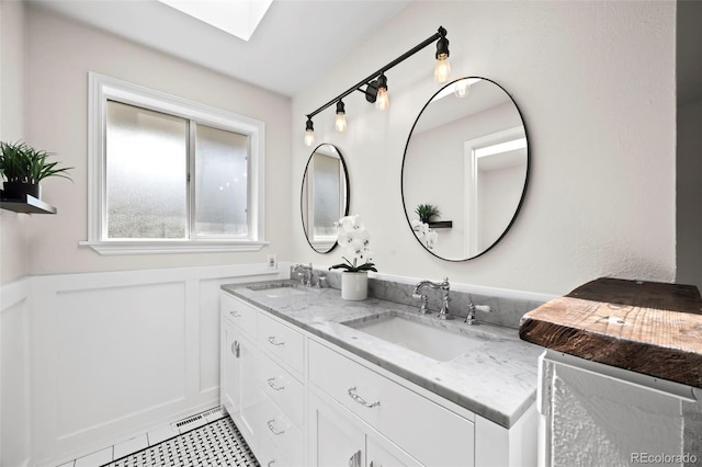 8035 S Garfield Way, Centennial, CO 80122 - full bath featuring double vanity, a skylight, and wainscoting