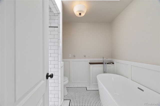 8035 S Garfield Way, Centennial, CO 80122 - bathroom featuring a freestanding tub, a wainscoted wall, toilet, and a decorative wall