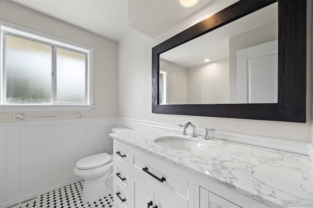 8035 S Garfield Way, Centennial, CO 80122 - bathroom featuring vanity, toilet, and a wainscoted wall