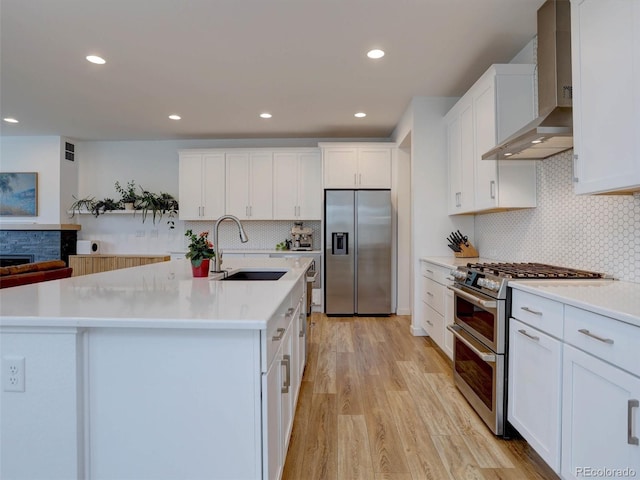 11246 Bellsong Ln, Littleton, CO 80125 - kitchen featuring wall chimney range hood, appliances with stainless steel finishes, decorative backsplash, white cabinetry, and recessed lighting