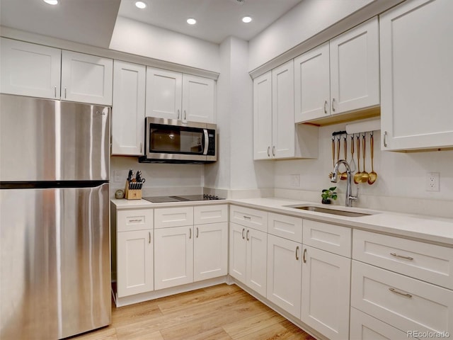 11246 Bellsong Ln, Littleton, CO 80125 - kitchen with appliances with stainless steel finishes, light countertops, recessed lighting, white cabinets, and light wood finished floors