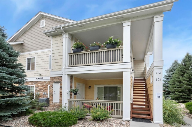 view of front of house with a balcony and central AC