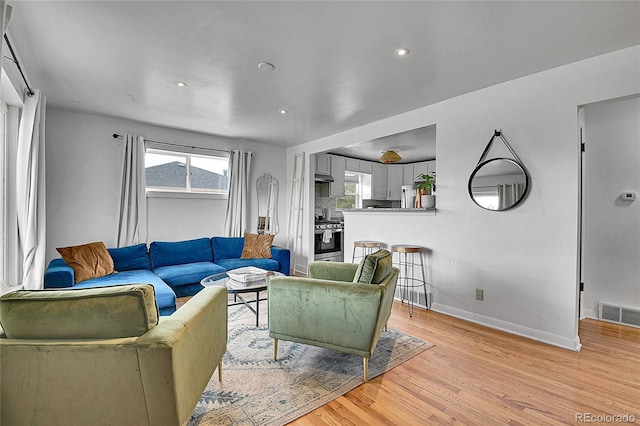 living area featuring recessed lighting, baseboards, visible vents, and light wood-style flooring