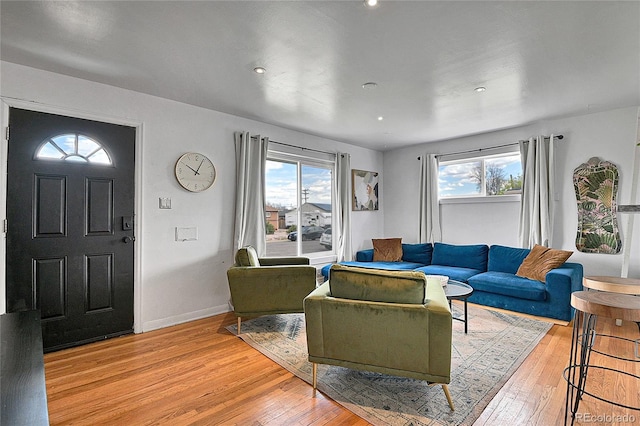 living area with light wood-type flooring, recessed lighting, and baseboards