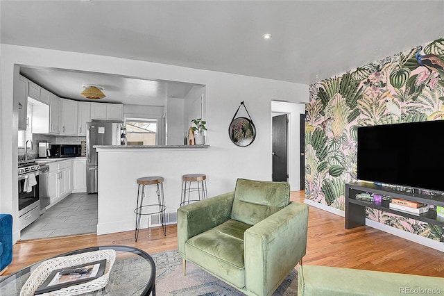 living area featuring baseboards and light wood-style flooring