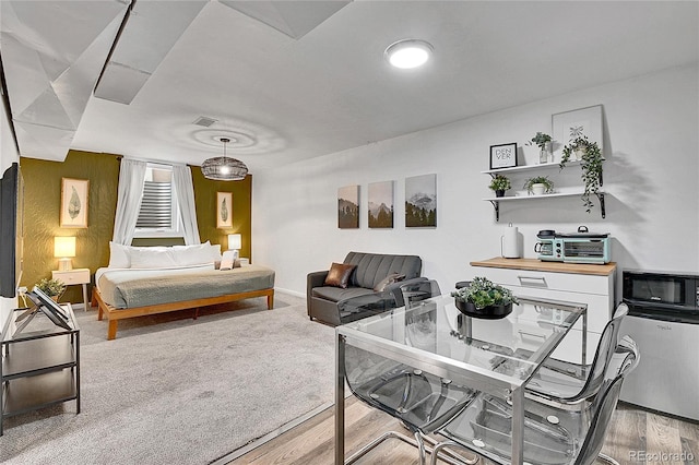 bedroom featuring baseboards, visible vents, and wood finished floors