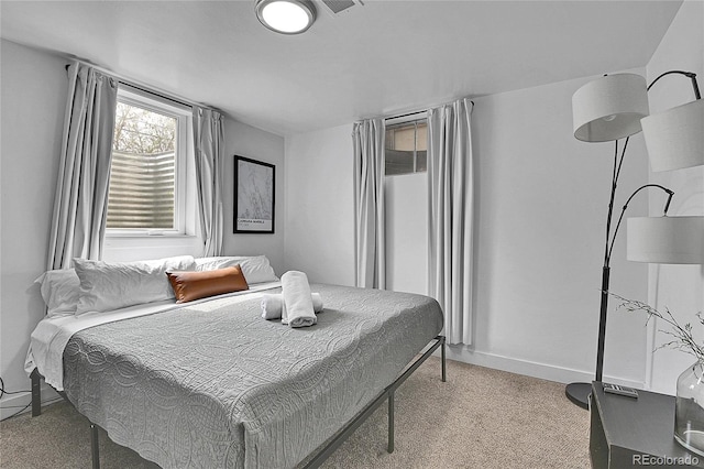bedroom featuring baseboards and light colored carpet