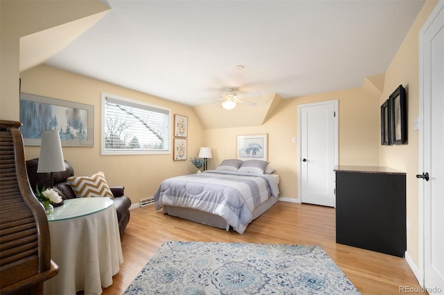 bedroom with baseboards, ceiling fan, vaulted ceiling, and light wood finished floors