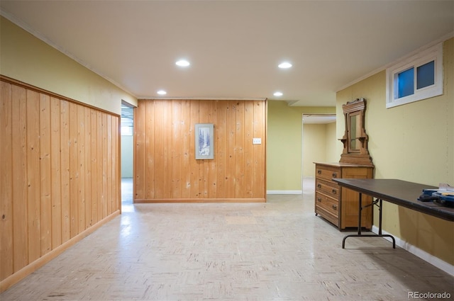 interior space with crown molding, wooden walls, recessed lighting, and baseboards