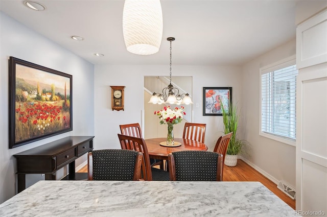 dining room featuring visible vents, baseboards, recessed lighting, light wood-style floors, and a notable chandelier