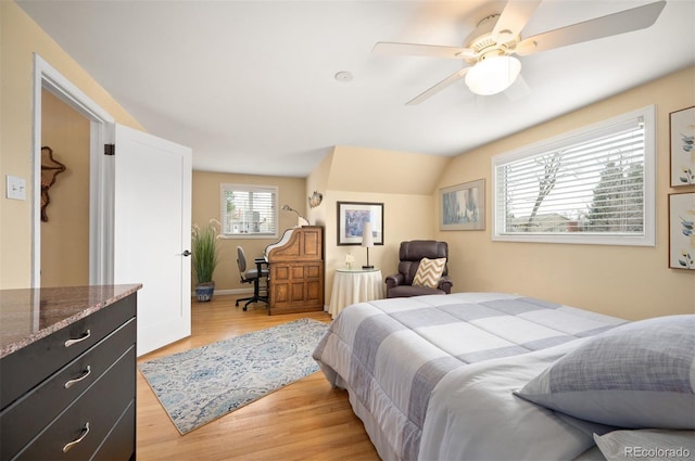 bedroom with light wood-type flooring, a ceiling fan, and vaulted ceiling