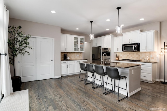6236 S Millbrook Way, Aurora, CO 80016 - kitchen with stainless steel appliances, dark wood-type flooring, tasteful backsplash, a kitchen breakfast bar, and recessed lighting