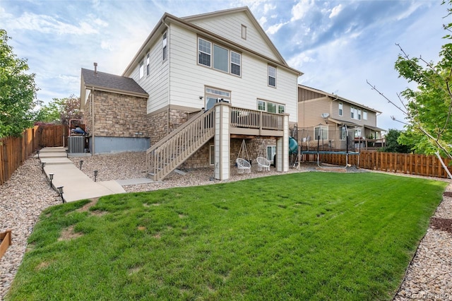 6236 S Millbrook Way, Aurora, CO 80016 - back of property featuring a trampoline, stairway, stone siding, a fenced backyard, and a wooden deck