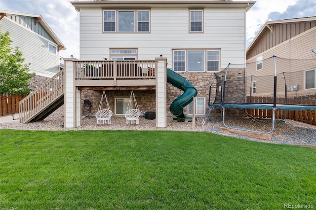 6236 S Millbrook Way, Aurora, CO 80016 - back of property featuring a trampoline, a deck, stairs, stone siding, and a playground